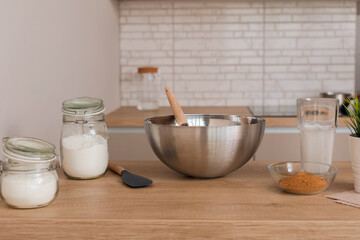 Concept of vegetarian baking background in modern home kitchen interior in light colors. Ingredients for cooking: rice flour, coconut milk, coconut palm sugar.