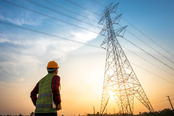 electrical engineer working at the power station See the planning of electricity production at high voltage poles.