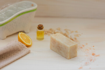 Organic brown soap with a mini-bath on the background of light natural wood with lemon, olive oil, cinnamon sticks . The concept of self-care, eco friendly products.