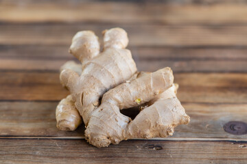 fresh ginger root on rustic wooden board blackground