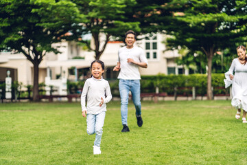 Fototapeta premium Portrait of enjoy happy love asian family father and mother with little asian girl smiling running playing and having fun moments good time in summer park at home