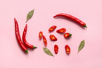 Hot chili peppers and bay leaves on color background - obrazy, fototapety, plakaty