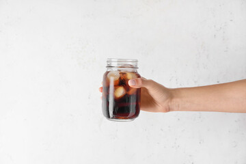 Female hand with mason jar of cold brew coffee on white background - Powered by Adobe