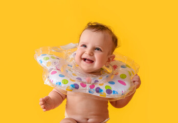 Cute baby with inflatable ring on color background