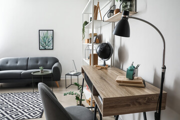 Modern workplace and book shelf near light wall