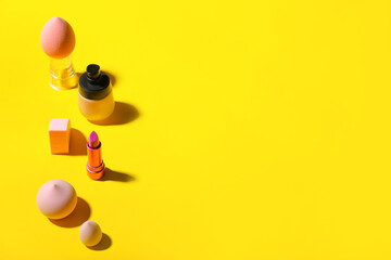 Different decorative cosmetics and makeup sponges on color background