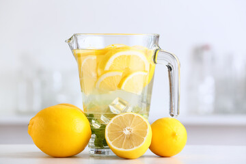 Jug of tasty cold lemonade in kitchen, closeup