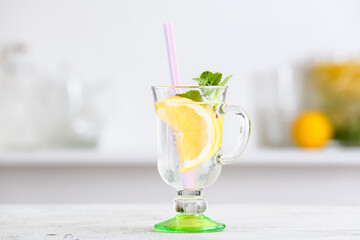 Glass of tasty cold lemonade in kitchen