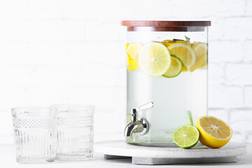 Jug of tasty cold lemonade on light background