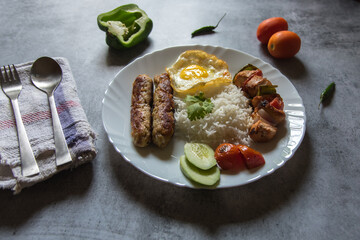 Middle eastern delicacy chelo kebab made of meat kebabs that are grilled and served with grilled tomatoes and basmati or flavoured rice. Close up.