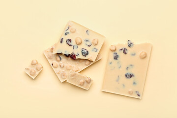 Pieces of tasty white chocolate on color background