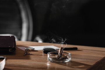 Obraz na płótnie Canvas Ash tray with cigar on table of detective