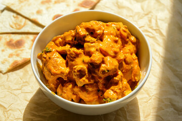 Bowl of tasty chicken tikka masala on table