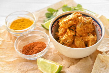 Bowl of tasty chicken tikka masala on table