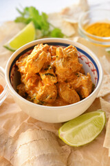 Bowl of tasty chicken tikka masala on table