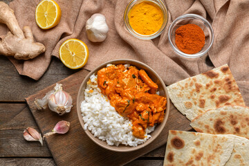 Bowl of tasty chicken tikka masala and rice on table