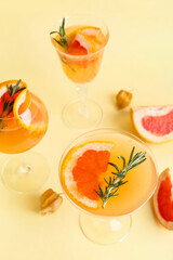 Glasses of tasty grapefruit cocktail on color background