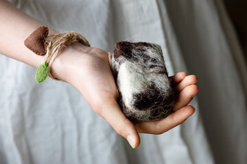 A girl's hand with felted woolen soap. The concept of a washcloth peeling. Self-care.