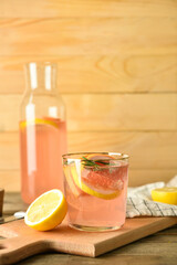 Composition of tasty grapefruit lemonade on wooden background