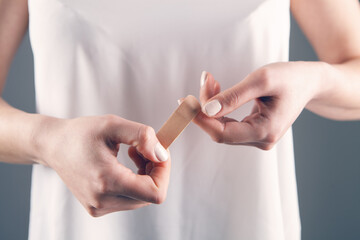 young woman attaches a plaster to her finger