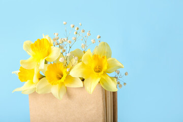 Bag with beautiful daffodils on color background