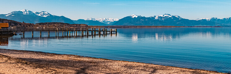 Beautiful alpine spring view with a pier and the alps in the background at the famous Chiemsee, Chieming, Chiemgau, Bavaria, Germany