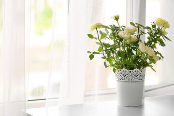 Fototapeta premium Beautiful white roses in pot on table in room