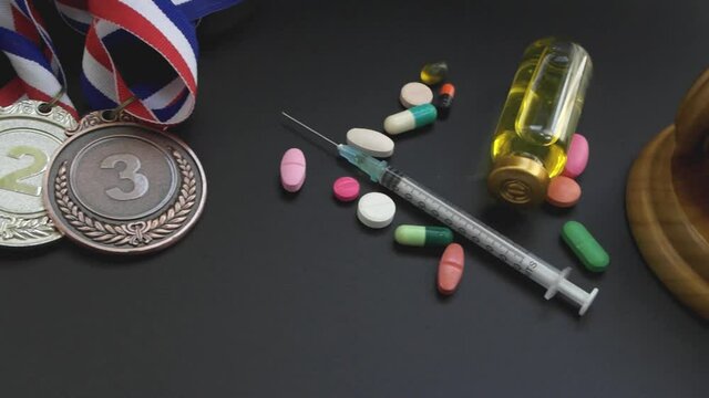 Doping in sport. Judge gavel, medals and drugs with syringe close-up.