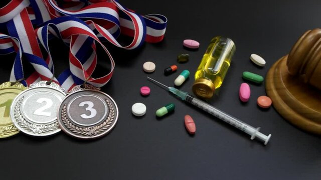 Doping in sport. Judge gavel, medals and drugs with syringe close-up.	
