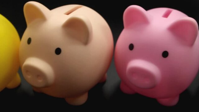 Different investments and savings funds concept. Camera moving above many colorful piggy banks.	