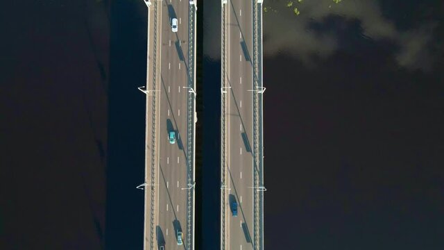 Cars traffic on bridge over the river in city, aerial view. Top view of bridge over Sozh river in Gomel, Belarus. Birds eye view cityscape