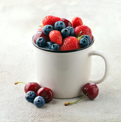 Sweet strawberies and blueberries in mug