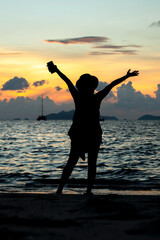 Fototapeta premium sunset at the beach with the shadow of a girl
