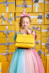 awesome little girl received the coveted yellow handbag as a gift on birthday, child wanted it for a long time, dreams come true concept