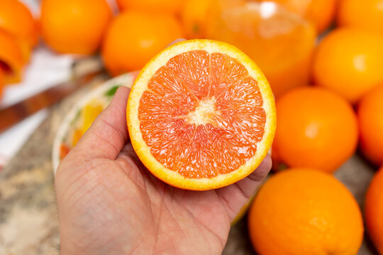 A Closeup View Of A Hand Holding Half Of A Cara Cara Orange.