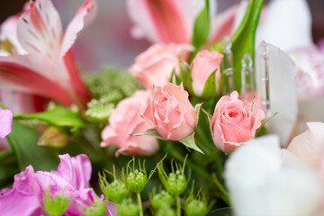 A view of a flower bouquet, featuring a few petite pink roses.