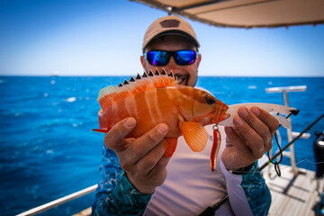 Fishing. Fisherman and red snapper. Blurred background.