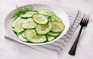 Fresh cucumber salad in bowl on white background