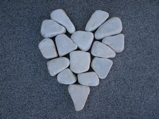 a hart in white stone on a background of gray granite