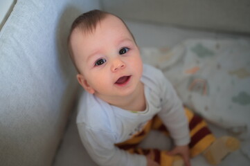 Portrait of cute little baby sitting in his crib