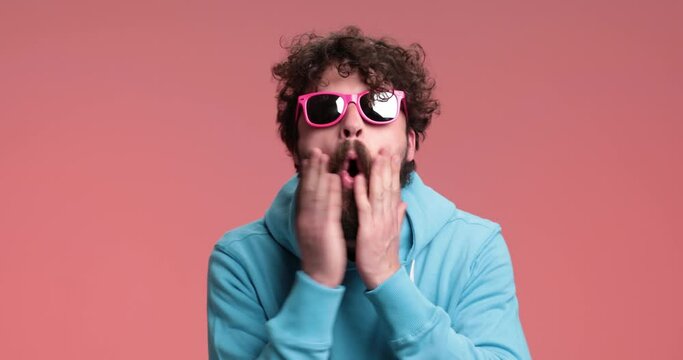 sexy casual man laughing out loud then slapping his face and fixing his mustache