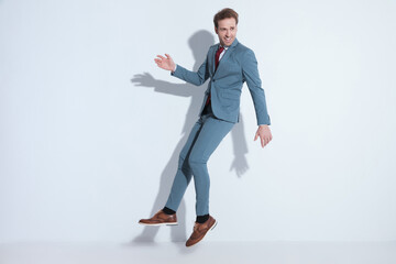 happy bearded businessman in elegant suit smiling and jumping