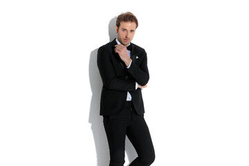 attractive fashion businessman posing with attitude and folding his arms