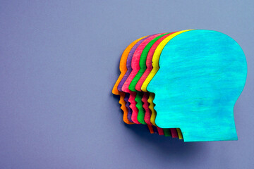 Wooden head with different colors as symbol of diversity and inclusion.