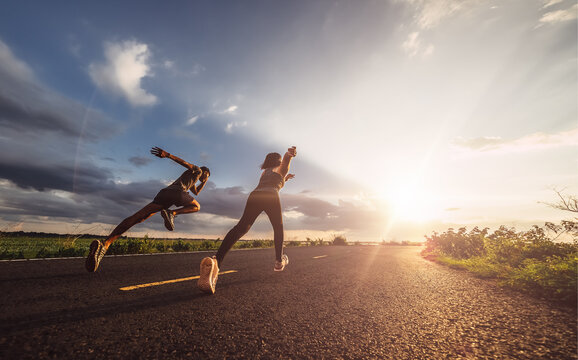 Young Couples Running Sprinting At Sunset Times. Fit Runner Fitness Runner During Outdoor Workout.