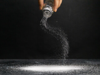 man sprinkles salt from a salt shaker