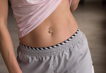 woman showing flat belly sports press piercing