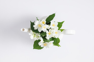 Jasmine tea and jasmine flowers.Teapot with jasmine flowers on white background. Flat lay, top...