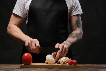 tattooed chief with the tattoo sleeve making the pizza