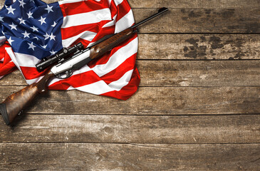 Automatic rifle on USA flag on wooden background